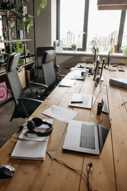 Un espace de travail contemporain où des mains étudient des données marketing sur un ordinateur portable et des documents papier.